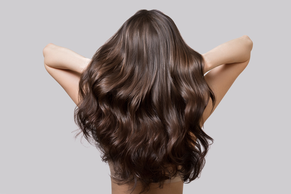 woman touching her shiny healthy hair